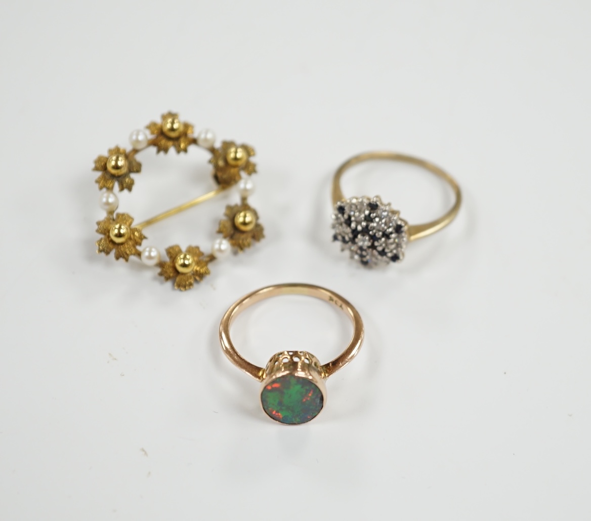 A 9ct gold and two colour sapphire cluster set dress ring, one other 9ct and opal ring and a 9ct gold and cultured pearl set open work circular brooch, gross weight 8.5 grams.